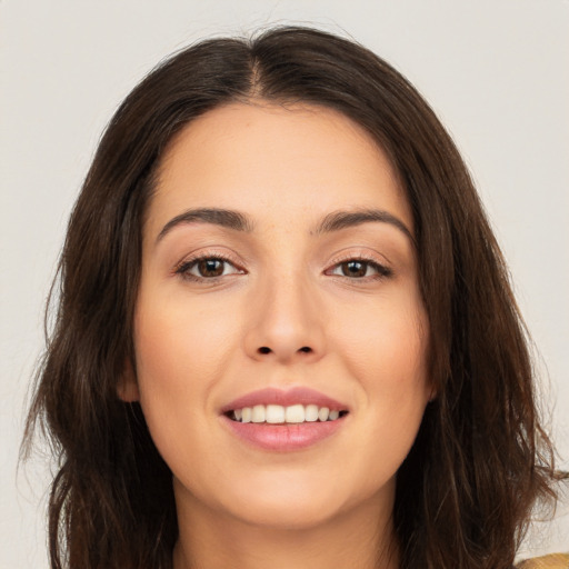 Joyful white young-adult female with long  brown hair and brown eyes