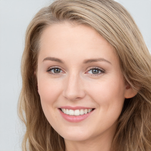 Joyful white young-adult female with long  brown hair and blue eyes