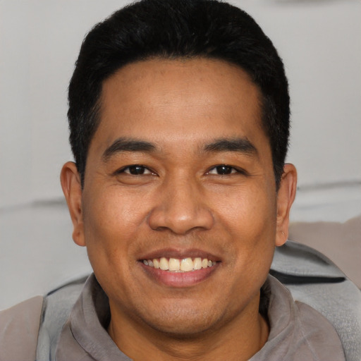 Joyful asian young-adult male with short  black hair and brown eyes