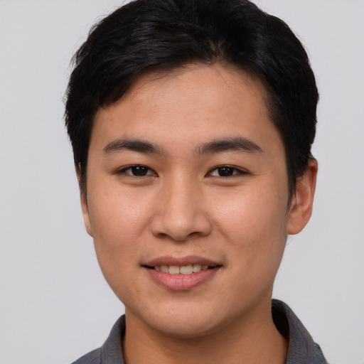 Joyful asian young-adult male with short  brown hair and brown eyes