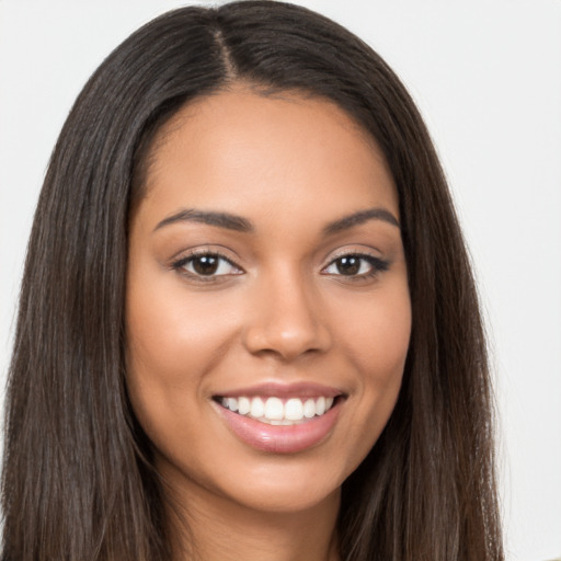 Joyful latino young-adult female with long  brown hair and brown eyes