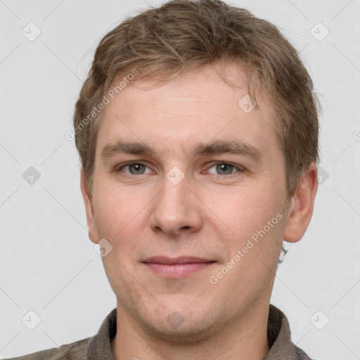 Joyful white young-adult male with short  brown hair and grey eyes