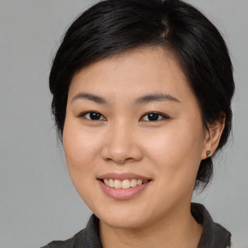 Joyful asian young-adult female with medium  brown hair and brown eyes