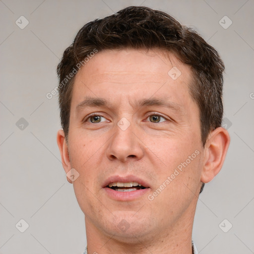 Joyful white adult male with short  brown hair and grey eyes