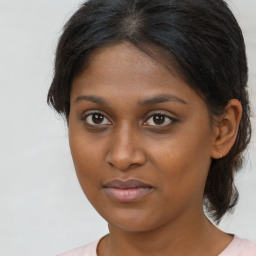 Joyful black young-adult female with medium  brown hair and brown eyes