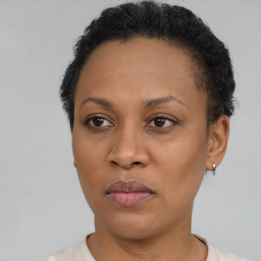 Joyful black adult female with short  brown hair and brown eyes