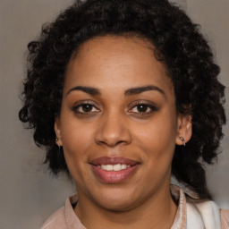 Joyful black adult female with medium  brown hair and brown eyes