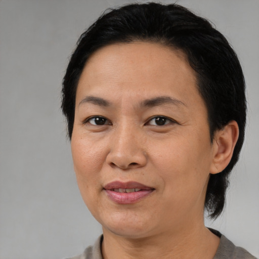 Joyful asian adult female with medium  black hair and brown eyes