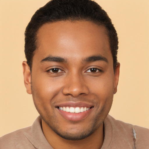 Joyful black young-adult male with short  brown hair and brown eyes