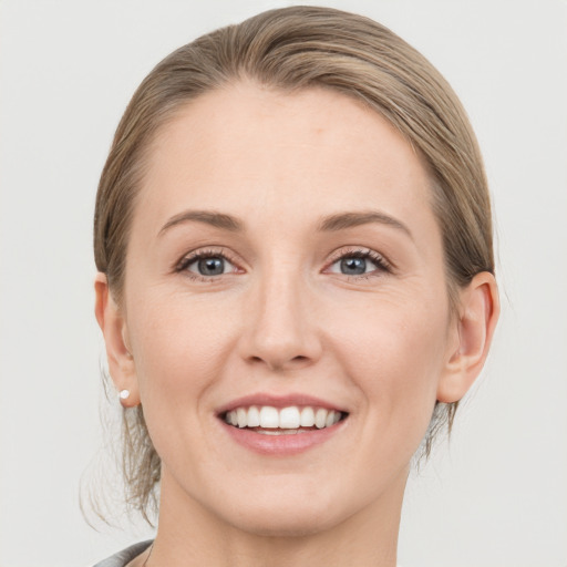 Joyful white young-adult female with medium  brown hair and grey eyes