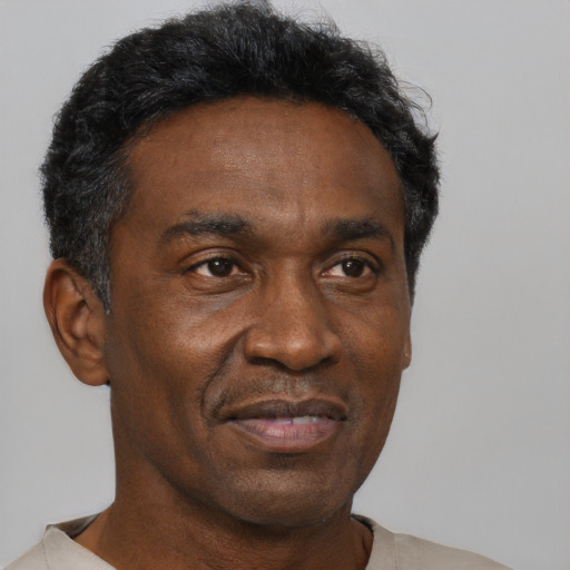 Joyful black adult male with short  black hair and brown eyes