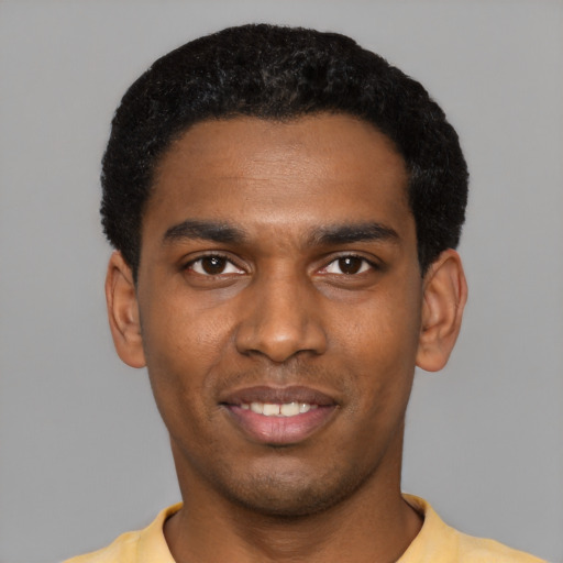 Joyful black young-adult male with short  black hair and brown eyes