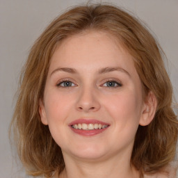 Joyful white young-adult female with long  brown hair and blue eyes