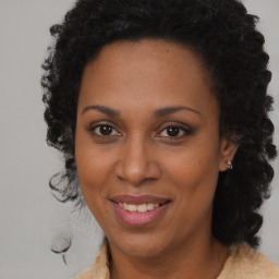 Joyful black adult female with long  brown hair and brown eyes