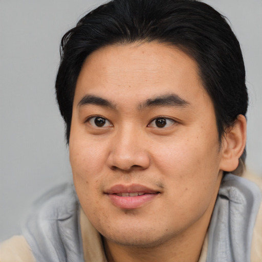 Joyful asian young-adult male with medium  brown hair and brown eyes