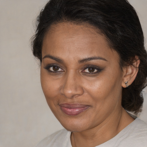 Joyful black adult female with medium  brown hair and brown eyes