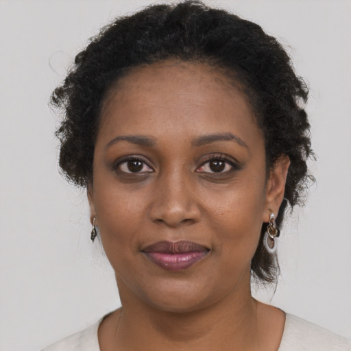 Joyful black young-adult female with short  brown hair and brown eyes