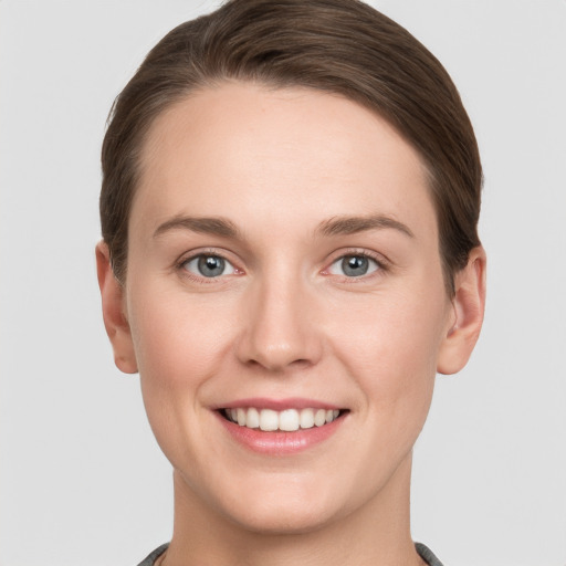 Joyful white young-adult female with short  brown hair and grey eyes