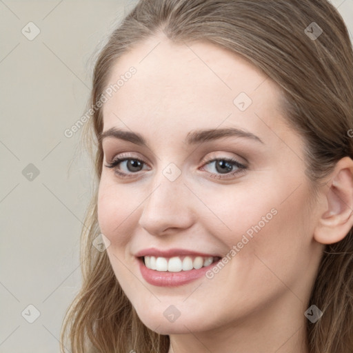 Joyful white young-adult female with long  brown hair and blue eyes