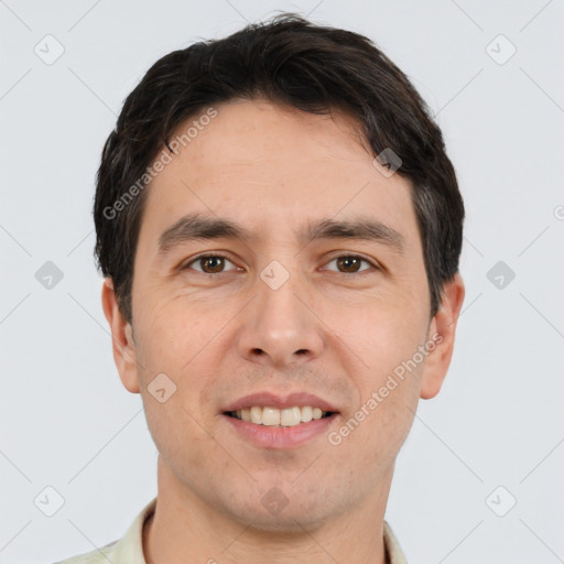 Joyful white young-adult male with short  black hair and brown eyes