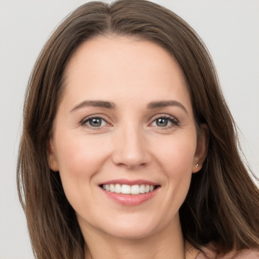 Joyful white young-adult female with long  brown hair and grey eyes