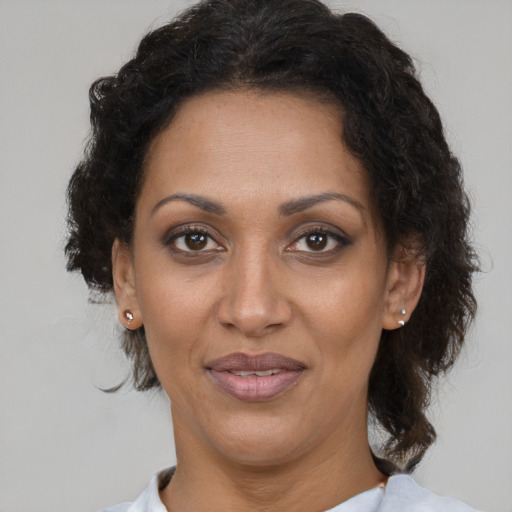Joyful black adult female with short  brown hair and brown eyes