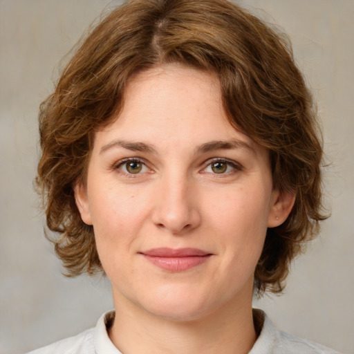 Joyful white young-adult female with medium  brown hair and green eyes