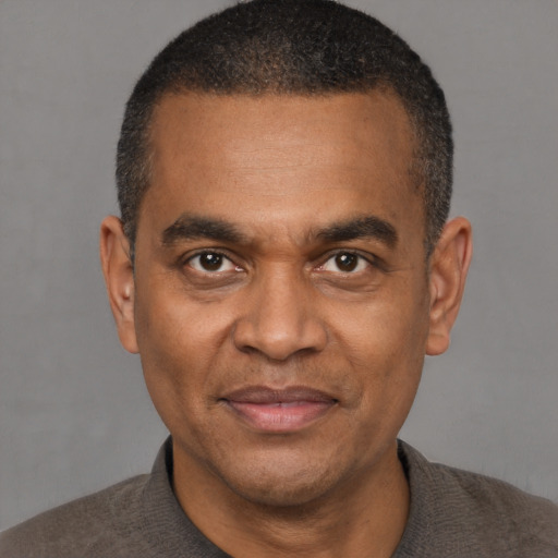 Joyful black adult male with short  brown hair and brown eyes