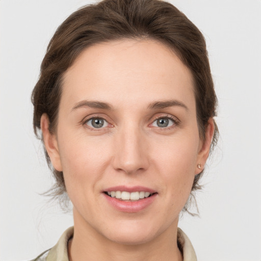 Joyful white young-adult female with medium  brown hair and grey eyes