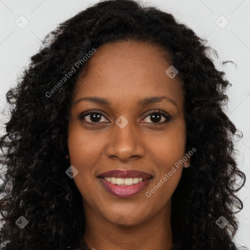 Joyful black young-adult female with long  brown hair and brown eyes