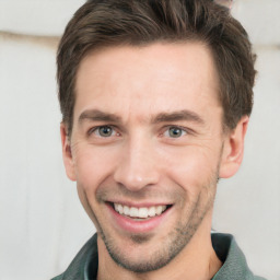 Joyful white young-adult male with short  brown hair and grey eyes