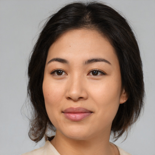 Joyful asian young-adult female with medium  brown hair and brown eyes
