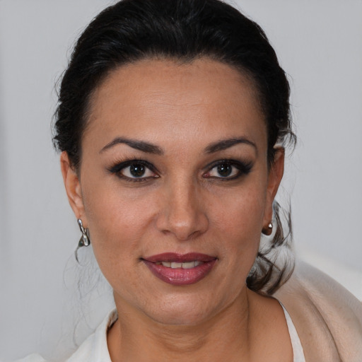 Joyful latino adult female with short  brown hair and brown eyes