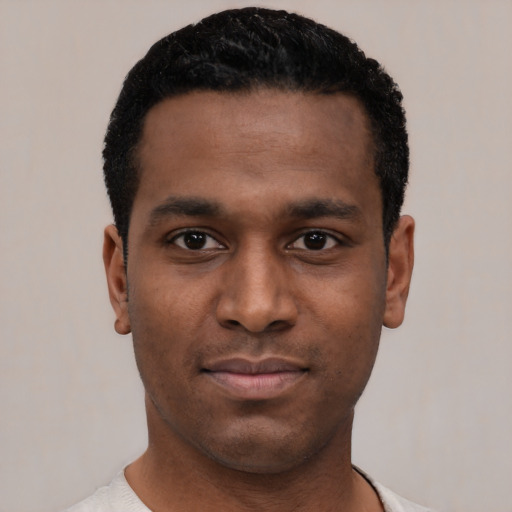 Joyful black young-adult male with short  black hair and brown eyes