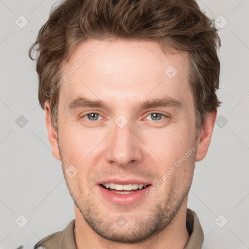 Joyful white young-adult male with short  brown hair and grey eyes