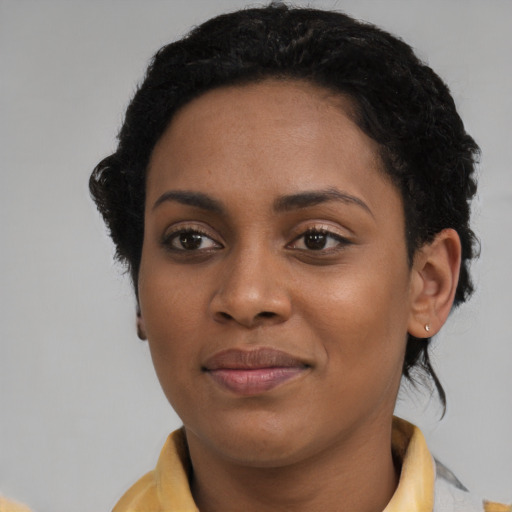 Joyful black young-adult female with short  brown hair and brown eyes