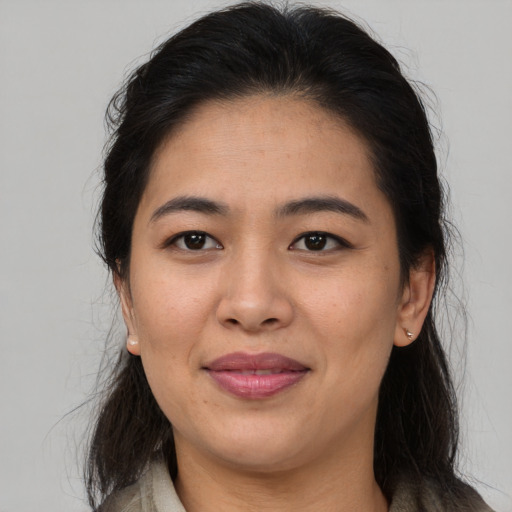 Joyful asian adult female with long  brown hair and brown eyes