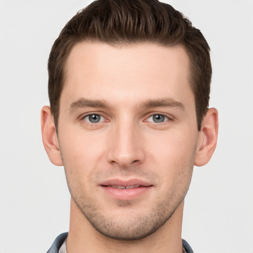 Joyful white young-adult male with short  brown hair and grey eyes