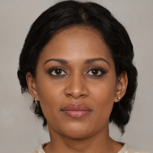 Joyful black young-adult female with medium  brown hair and brown eyes