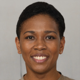 Joyful black young-adult female with short  black hair and brown eyes