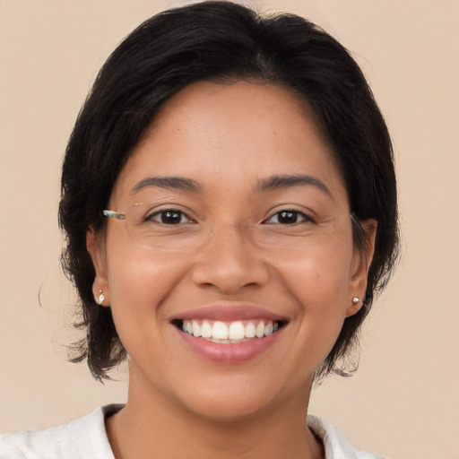 Joyful latino young-adult female with medium  brown hair and brown eyes