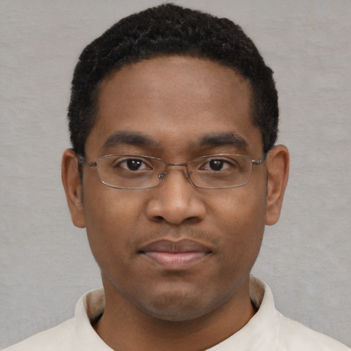 Joyful black young-adult male with short  brown hair and brown eyes