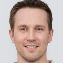 Joyful white young-adult male with short  brown hair and grey eyes