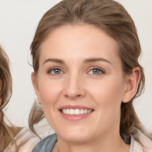 Joyful white young-adult female with medium  brown hair and blue eyes