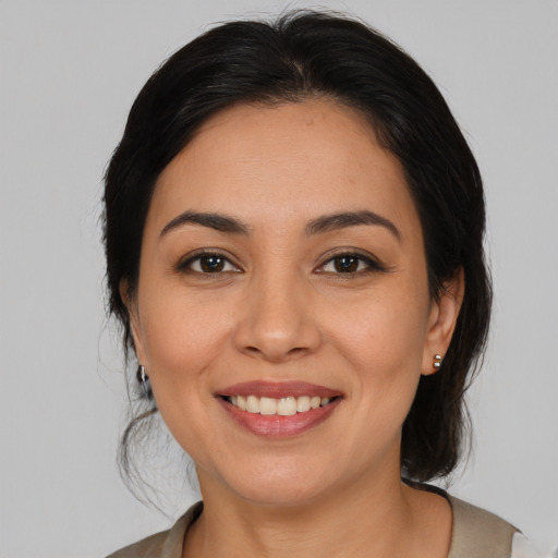 Joyful latino young-adult female with medium  brown hair and brown eyes