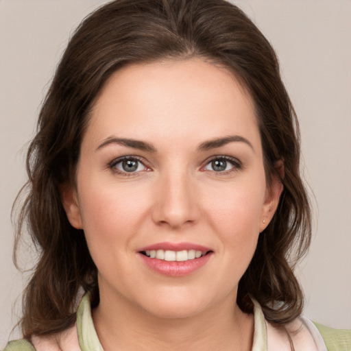 Joyful white young-adult female with medium  brown hair and green eyes