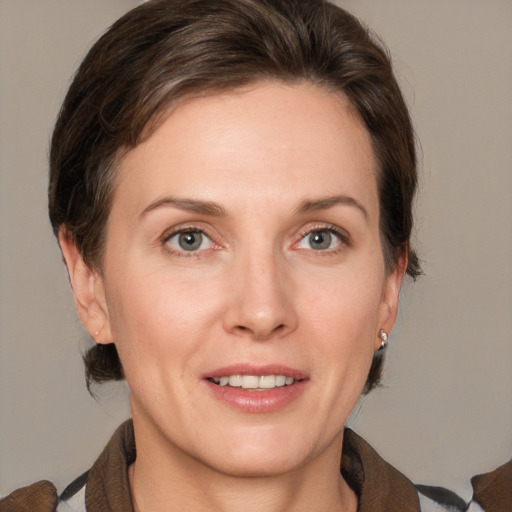 Joyful white adult female with medium  brown hair and grey eyes