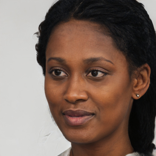 Joyful black young-adult female with medium  black hair and brown eyes