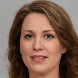 Joyful white adult female with long  brown hair and green eyes