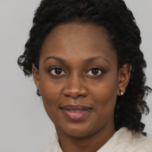 Joyful black young-adult female with short  black hair and brown eyes